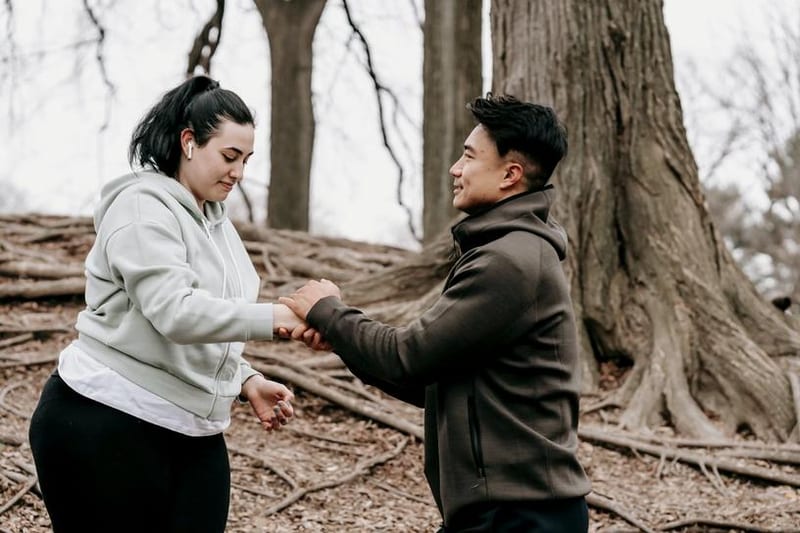 A coach steadies a client during an outdoor training session in a park